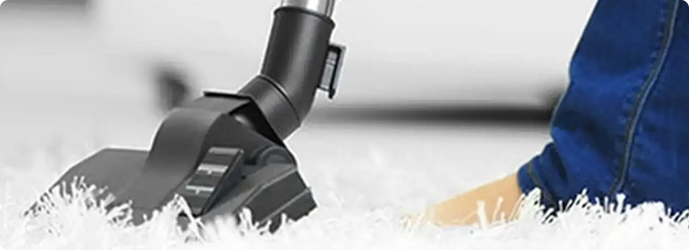 Close-up of a professional vacuuming a white carpet in Portsmouth.